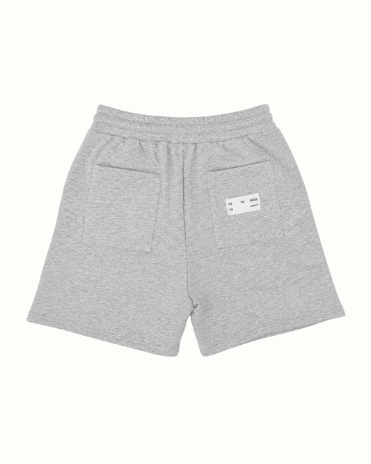 Light gray heathered sweat shorts with an elastic waistband, featuring a side pocket and a small white brand label on the back.