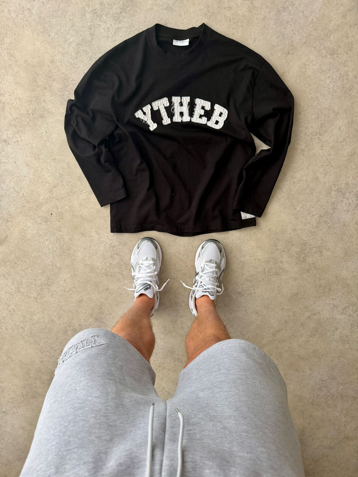 Black YTHEB long sleeve laid flat above white trainers, worn with grey marl YTHEB shorts