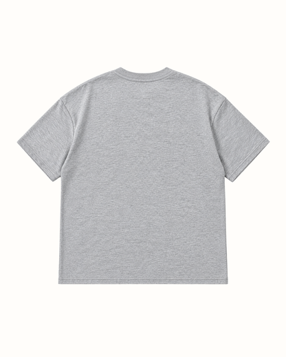 Plain back of the light grey marl YTHEB appliqué T-shirt, showing the dropped shoulders and ribbed crew neck.